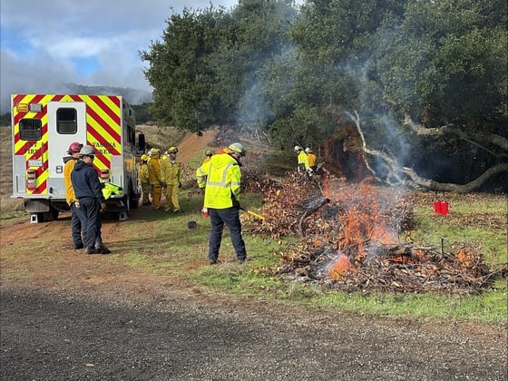 Santa Clara County Fire and Midpen staff conduct pile burns beside an emergency vehicle
