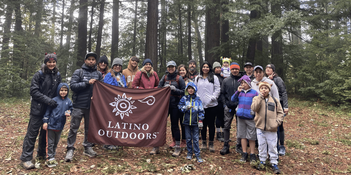 Hiking group holding a Latino Outdoors banner