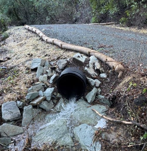 Photo of sections of retaining wall with water flowing through new culvert