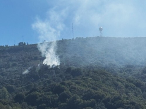 Photo of smoke rising from a vegetated hillside in Sierra Azul Open Space Preserve