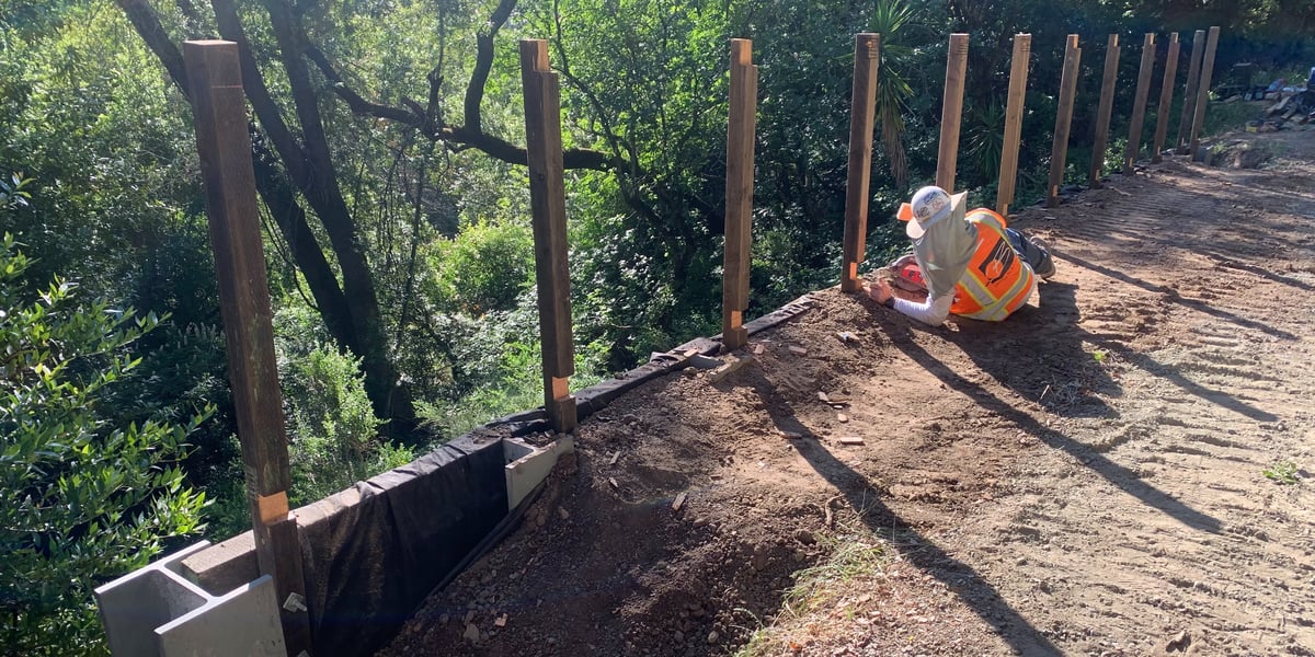 Photo of construction worker installing retaining wall in Bear Creek Redwoods preserve
