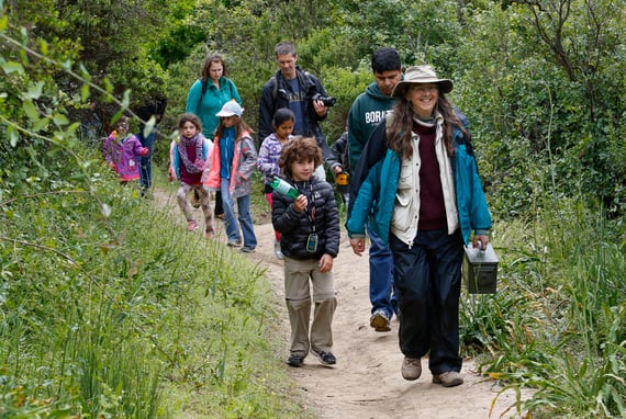 Group of children and parents walk along a trail