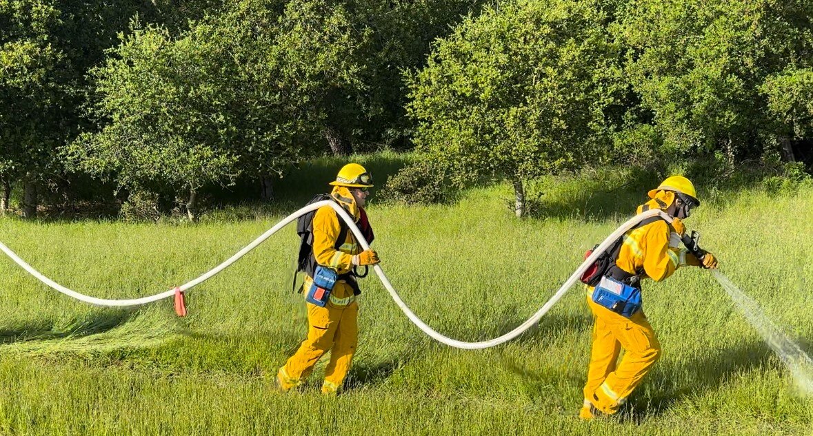 Two firefighters practicing hose-lays