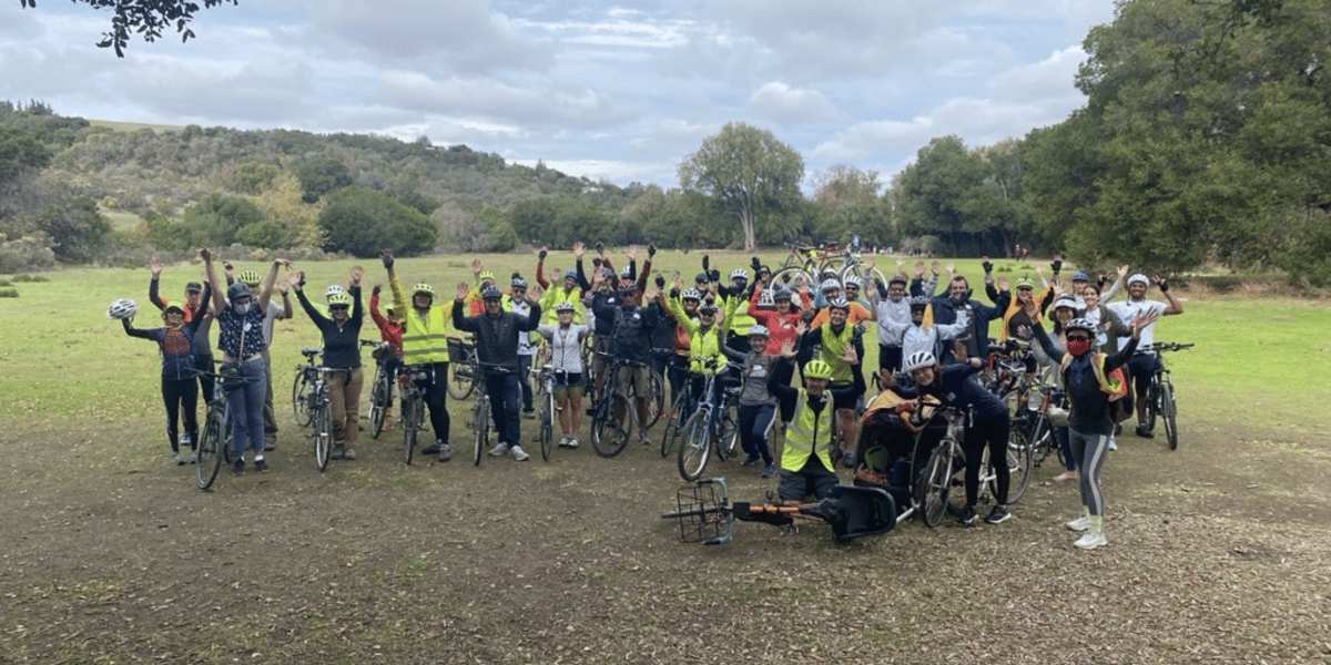 A group of people riding bikes poses for photo